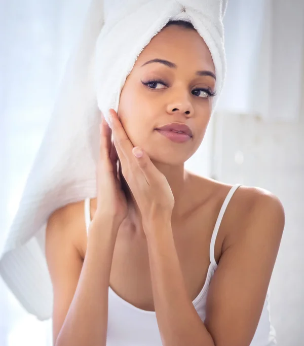 Woman looking at herself in the mirror - Acne Scar Removal in Toronto, ON